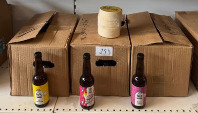 Plusieurs bouteilles de bière sont alignées sur une étagère dans un magasin.