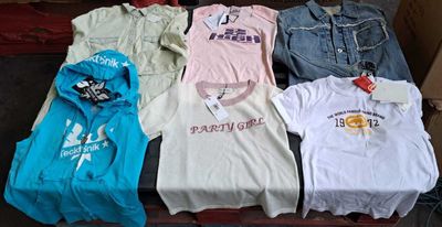 un grand nombre de t-shirts posés sur une table