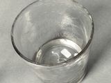 a glass with a small amount of water inside of it