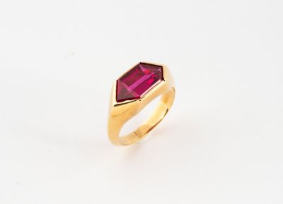 gros plan d'une bague en or avec une pierre rouge