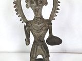 an old bronze statue of a man holding a bell in his hand