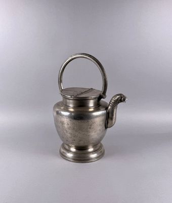 an antique silver teapot with a handle on a white background