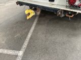 a truck with a cage on the back parked in a parking lot