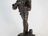 bronze figurine of a boy playing a trumpet