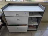 une commode blanche et grise à tiroirs dans une pièce