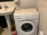 a washer and a toilet in a small bathroom