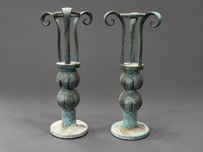 une paire de vases anciens en bronze sur socles, sur fond gris