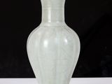a white vase sitting on a table with a black background
