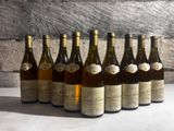 six bottles of wine are lined up in a row on a table