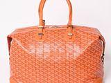 a small orange bag with a logo on the front