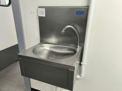 un évier en acier inoxydable avec un robinet dans un coin