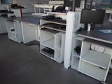 many desks with computers on them in a large room
