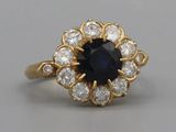 un gros plan d'une bague sertie d'un saphir bleu et de diamants blancs