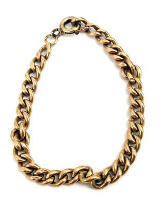 gros plan d'un bracelet en chaîne en or sur fond blanc