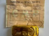 an old gold bar sitting on top of a piece of paper next to a receipt