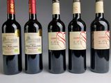 several bottles of wine are lined up in a row on a table
