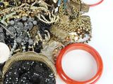 a pile of assorted jewelry on a white surface