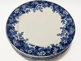 quatre assiettes bleues et blanches empilées les unes sur les autres sur une surface blanche