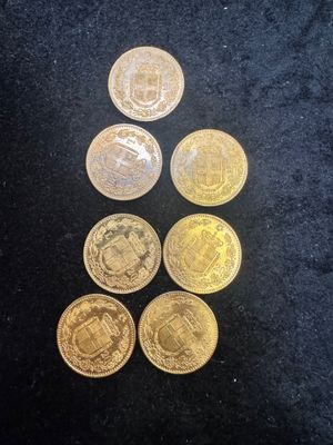 a pile of gold coins sitting on top of a black surface