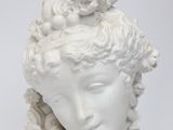 white marble bust of a woman with flowers in her hair
