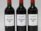 trois bouteilles de vin rouge posées côte à côte sur une table