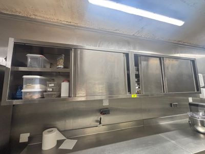 une grande cuisine équipée d'armoires et de plans de travail en inox