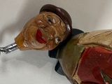 a figurine of a man holding a bottle opener