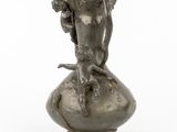 a statue of a woman sitting on top of a vase