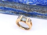une image représentant une bague en or sertie de deux diamants sur une pierre bleue