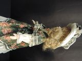 a doll that is wearing a dress and a hat