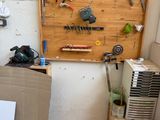 un établi en bois sur lequel sont posés des outils, dans un coin de la pièce