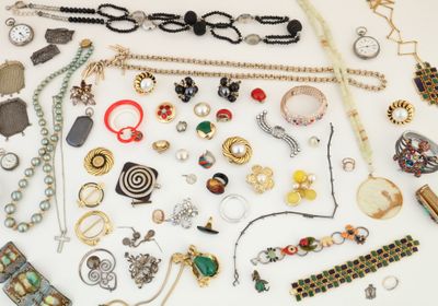 many different types of necklaces and bracelets laid out on a table