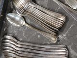 a lot of silverware sitting on a table next to a knife, fork, and spoon