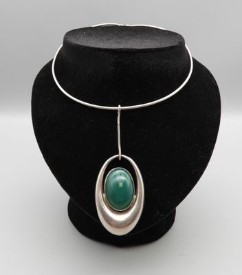 un collier orné d'une pierre verte sur un mannequin noir
