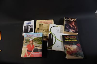 a lot of books on a table with a lamp