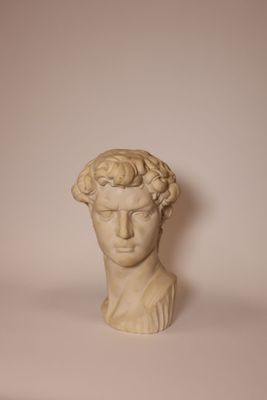 a close up of a statue of a man ' s head on a table