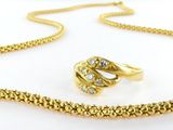 an image of a gold necklace and ring set on a white background
