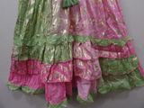 a pink and green dress hanging on a hanger