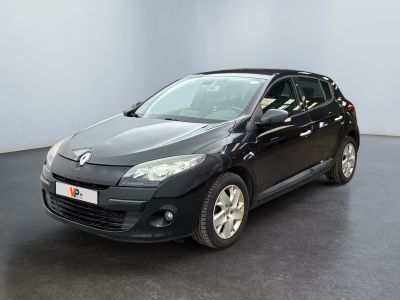 La voiture noire est garée dans une grande pièce au sol noir.