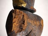 wooden sculpture of a man with a hat on top of his head