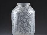 vase with etched design on the outside of it on a gray surface