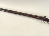 an old rifle with a wooden handle on a white surface