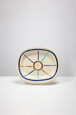 une image représentant une assiette blanche ornée d'un motif bleu et orange