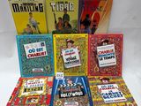 several children ' s books are lined up on a white surface