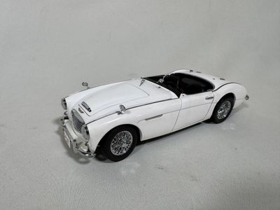 a white toy car that is sitting on a white surface