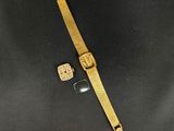 une montre en or et un bracelet en or sur un fond noir