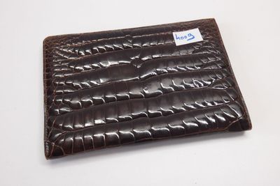portefeuille en cuir d'alligator marron avec une étiquette bleue sur le devant