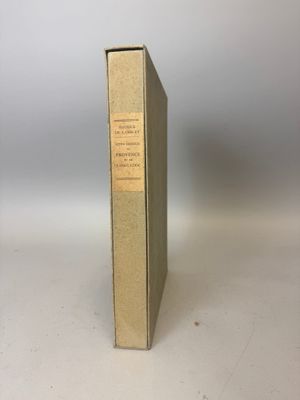 un vieux livre posé sur une table à côté d'un mur blanc