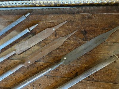 cinq types de couteaux différents posés sur une table en bois