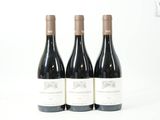trois bouteilles de vin posées sur une table blanche